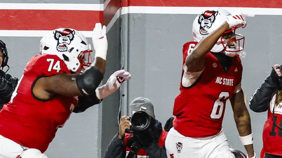 Nov 29, 2025; Raleigh, North Carolina, USA; NC State Wolfpack wide receiver Wesley Grimes (6) makes a touchdown and celebrates during the first half of the game against North Carolina Tar Heels at Carter-Finley Stadium.  Mandatory Credit: Jaylynn Nash-Imagn Images