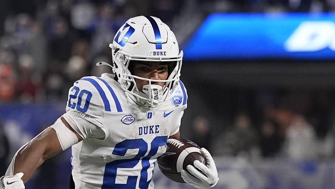Dec 6, 2025; Charlotte, NC, USA; Duke Blue Devils running back Nate Sheppard (20) tries to outrun Virginia Cavaliers safety Devin Neal (27) during the second half during the 2025 ACC Championship game at Bank of America Stadium. Mandatory Credit: Jim Dedmon-Imagn Images