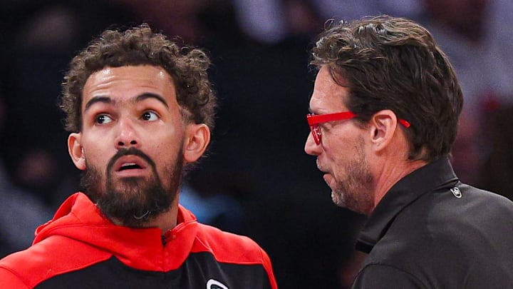 Trae Young #11 of the Atlanta Hawks speaks with head coach Quin Snyder during a game against the New York Knicks.