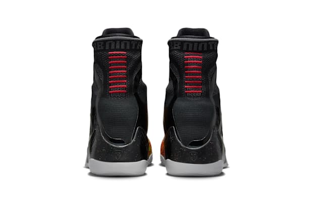 Red stitching on the heels of black Nike sneakers.
