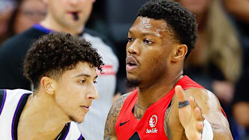 Sacramento Kings guard Nique Clifford controls the ball against Toronto Raptors guard Alijah Martin.
