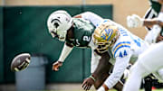 Michigan State's Aidan Chiles, left, fumbles after a hit by UCLA's Devin Aupiu during the second quarter on Saturday, Oct. 11, 2025, at Spartan Stadium in East Lansing.