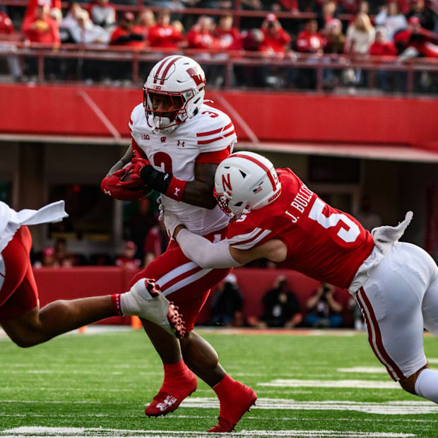 John Bullock (5) tackles Wisconsin's Tawee Walker (3). 