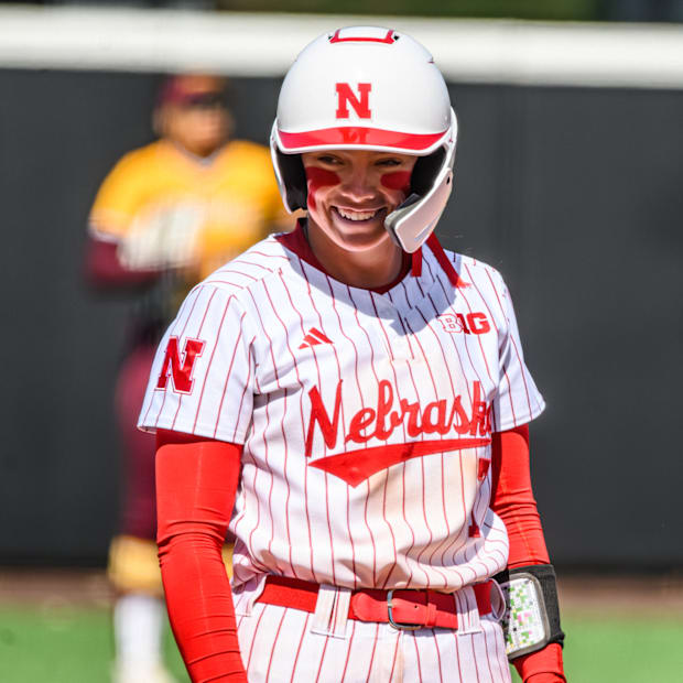 Ava Kuszak smiles while standing at third base. 