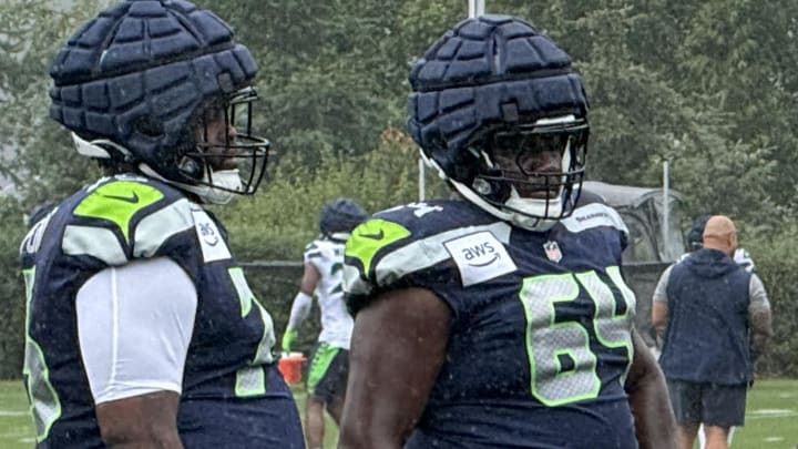 Seattle Seahawks guards Anthony Bradford (75) and Christian Haynes (64) listen to instruction from coach Scott Huff during a training camp practice at the Virginia Mason Athletic Center.