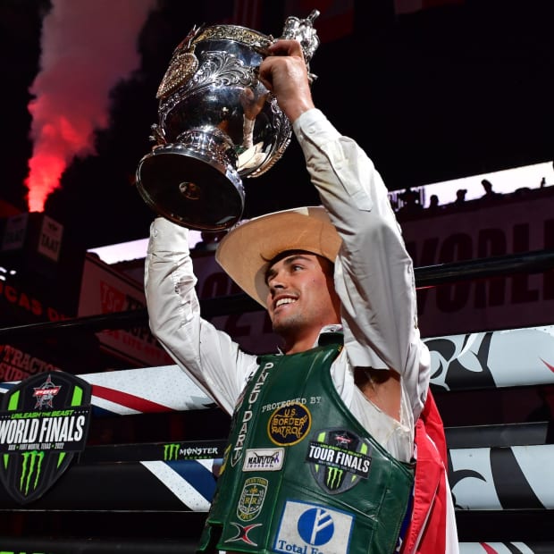 Bull rider holds up a trophy.