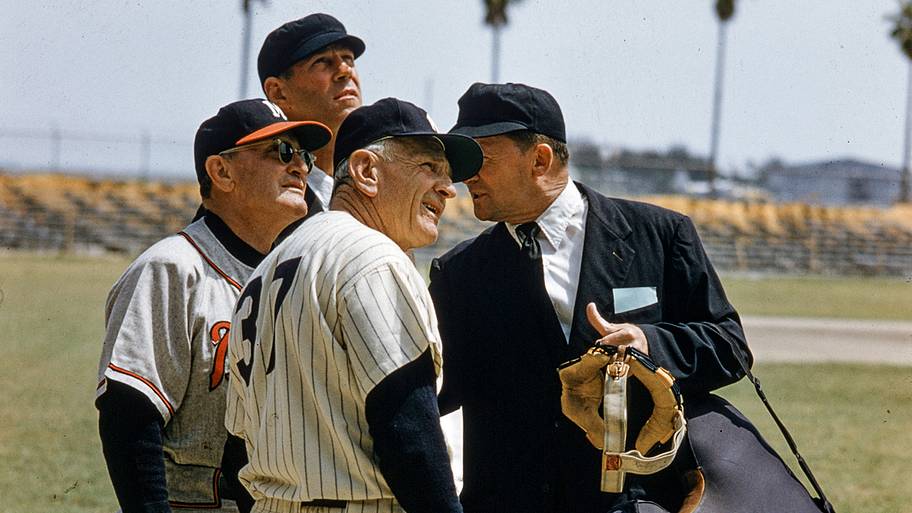 Yankees manager Casey Stengel and Milwaukee Braves manager Fred Haney speak with umpires during a 1957 spring training game.
