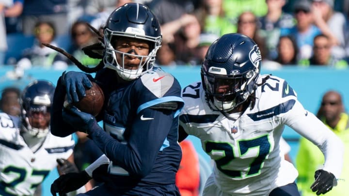 Tennessee Titans wide receiver DeAndre Hopkins (10) brings in a pass as Seattle Seahawks cornerback Riq Woolen (27) defends during their game at Nissan Stadium in Nashville, Tenn., Sunday, Dec. 24, 2023.