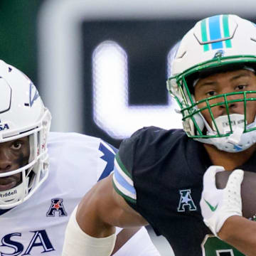 Nov 24, 2023; New Orleans, Louisiana, USA; Tulane Green Wave running back Makhi Hughes (21) runs against UTSA Roadrunners running back Kevorian Barnes (4) during the first half at Yulman Stadium. Mandatory Credit: Matthew Hinton-Imagn Images