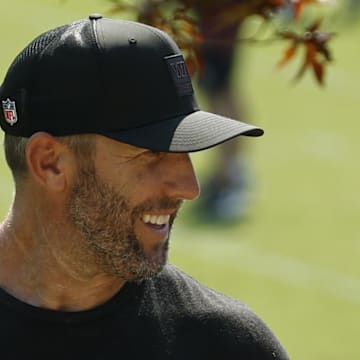 Washington Commanders general manager Adam Peters talks with Commanders head coach Dan Quinn.