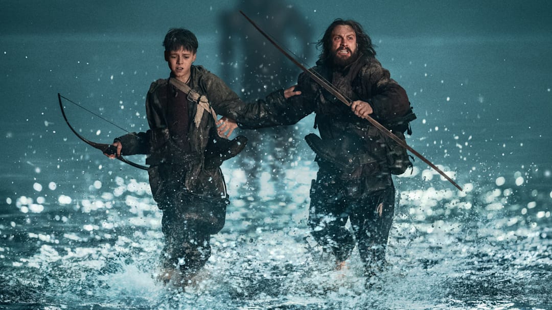 Jamie (Aaron Taylor-Johnson) and his son Spike (Alfie Williams) being chased by a Berserker in Columbia Pictures' 28 YEARS LATER. 