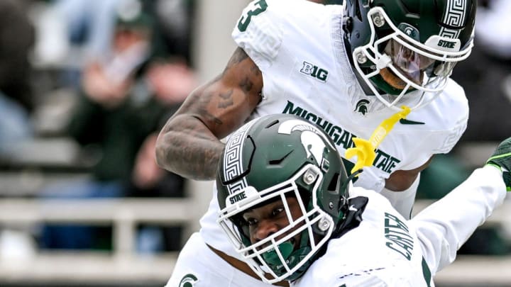 Michigan State's Nathan Carter, center, celebrates his touchdown with teammates Jack Velling, bottom, and Montorie Foster Jr., top, during the Spring Showcase on Saturday, April 20, 2024, at Spartan Stadium in East Lansing.