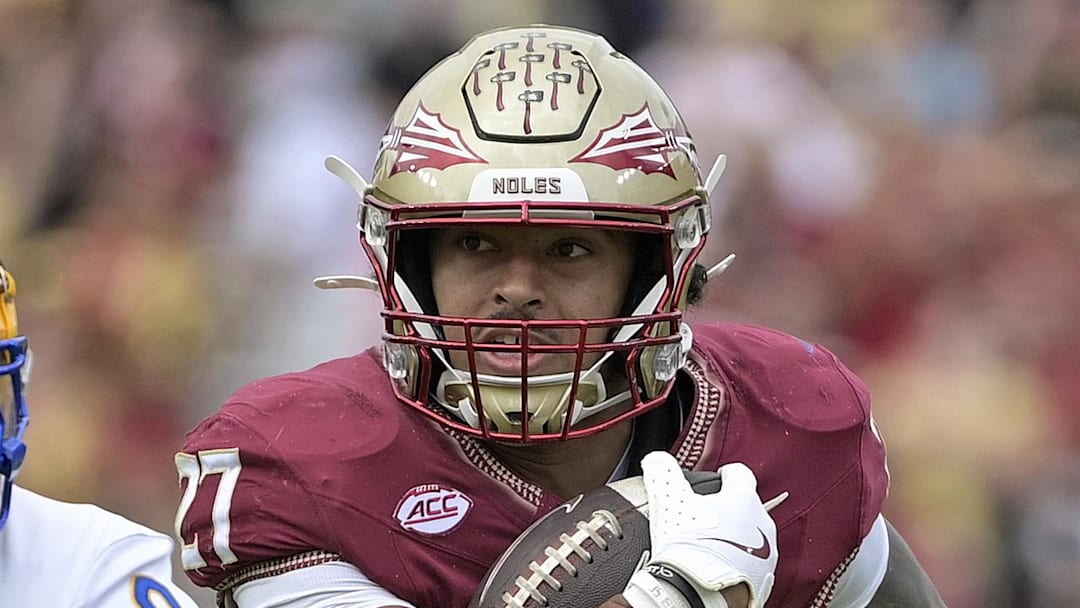 Oct 11, 2025; Tallahassee, Florida, USA; Florida State Seminoles running back Gavin Sawchuk (27) runs the ball past Pittsburgh Panthers linebacker Kyle Louis (9) during the first half at Doak S. Campbell Stadium. Mandatory Credit: Melina Myers-Imagn Images