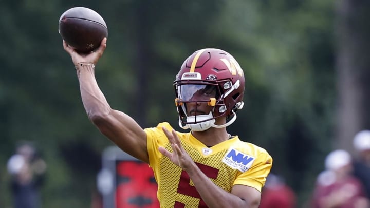 Jul 26, 2024; Ashburn, VA, USA; Washington Commanders quarterback Jayden Daniels (5) passes the ball on day three of training camp at Commanders Park. Mandatory Credit: Geoff Burke-USA TODAY Sports