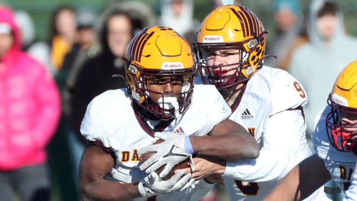 Davison quarterback Sawyer Glennie hands off to AJ Hill during first-half action at Novi High School on Saturday, Nov. 18, 2023.