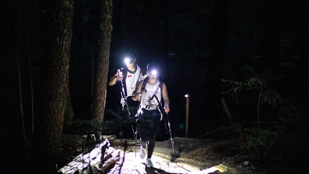 Two hikers climbing at night