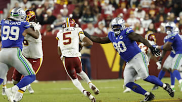 Nov 2, 2025; Landover, Maryland, USA; Washington Commanders quarterback Jayden Daniels (5) scrambles from Seattle Seahawks defensive tackle Jarran Reed (90) during the third quarter at Northwest Stadium. 