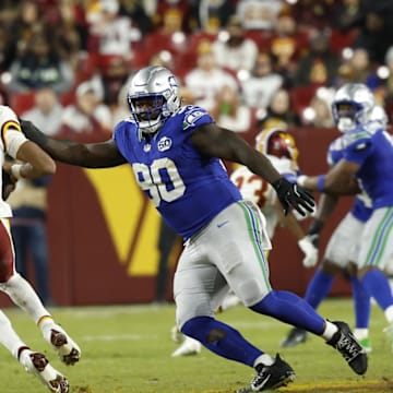Nov 2, 2025; Landover, Maryland, USA; Washington Commanders quarterback Jayden Daniels (5) scrambles from Seattle Seahawks defensive tackle Jarran Reed (90) during the third quarter at Northwest Stadium. 