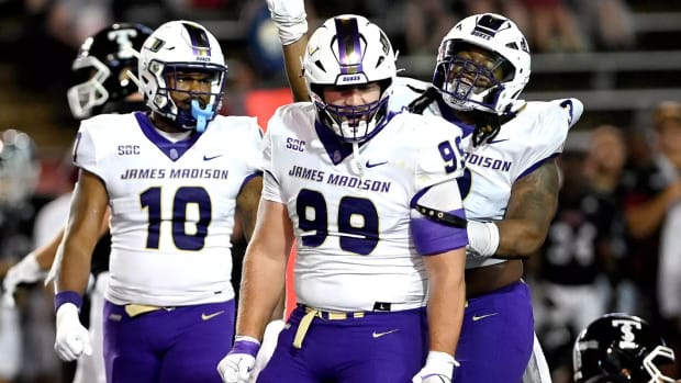 James Carpenter flexes with his teammates after they made a tackle in a game at Troy in 2023. 