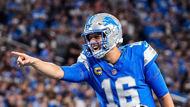 Detroit Lions quarterback Jared Goff (16) talks to teammates