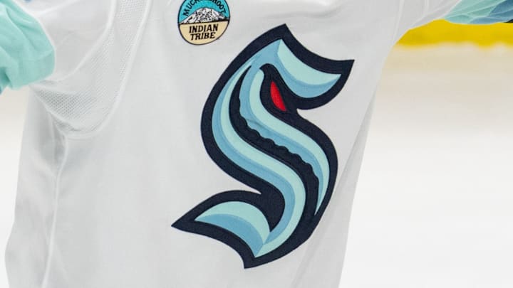 A Seattle Kraken logo on a white jersey. A Seattle Kraken logo on a white jersey.