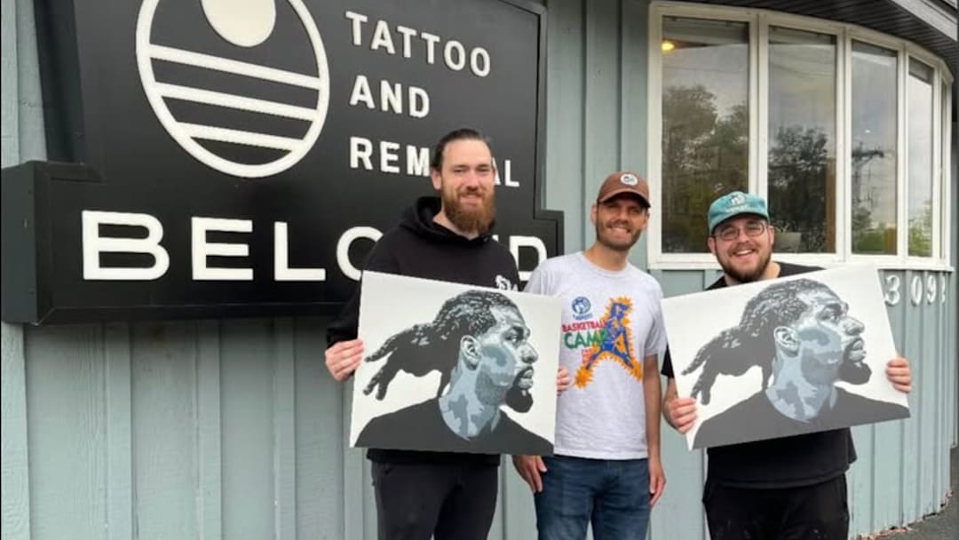 Jesse Stroebel (right) posing with a Naz Reid painting outside his tattoo shop in Roseville, Minnesota. 