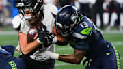 Oct 20, 2025; Seattle, Washington, USA; Seattle Seahawks linebacker Ernest Jones IV (13) tackles Houston Texans tight end Dalton Schultz (86) during the second quarter at Lumen Field.