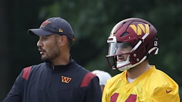 Washington Commanders quarterbacks coach Tavita Pritchard talks with quarterbacks Jacoby Brissett and Sam Howell.