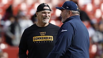 Washington Commanders head coach Dan Quinn (L) talks with Dallas Cowboys head coach Mike McCarthy (R) on the field during warmup prior to their game at Northwest Stadium.
