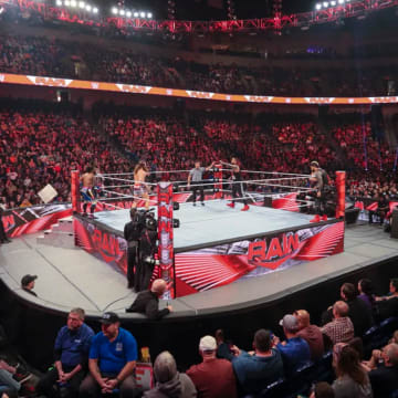A camera shot from the crowd during a tag team match on WWE Monday Night Raw.