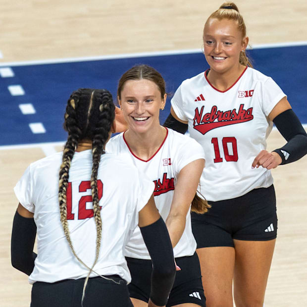 Nebraska setter Bergen Reilly and DS/Libero Olivia Mauch greet outside hitter Taylor Landfair