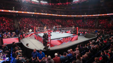 A camera shot from the crowd during a tag team match on WWE Monday Night Raw.