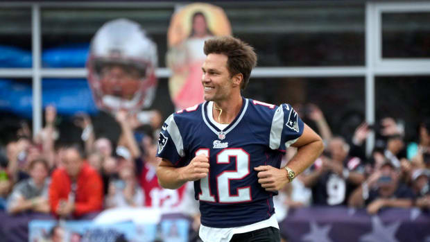 Former New England Patriots quarterback, Tom Brady, runs on to the field at Gillette Stadium on