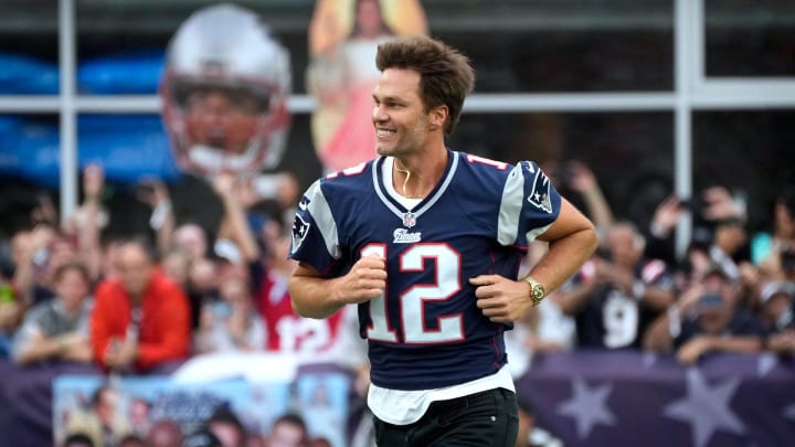 Former New England Patriots quarterback, Tom Brady, runs on to the field at Gillette Stadium on Sunday evening to welcome fans as the Patriots announce they will induct him into the Patriots Hall of Fame in June.