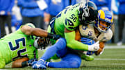 Oct 7, 2021; Seattle, Washington, USA; Los Angeles Rams wide receiver Cooper Kupp (10) is tackled by Seattle Seahawks middle linebacker Bobby Wagner (54) and linebacker Jordyn Brooks (56) after making a reception during the first quarter at Lumen Field.