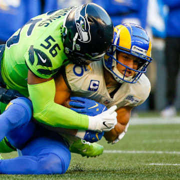Oct 7, 2021; Seattle, Washington, USA; Los Angeles Rams wide receiver Cooper Kupp (10) is tackled by Seattle Seahawks middle linebacker Bobby Wagner (54) and linebacker Jordyn Brooks (56) after making a reception during the first quarter at Lumen Field.