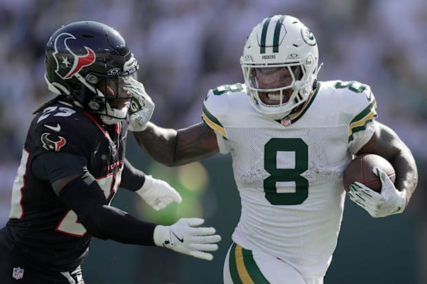 Green Bay Packers running back Josh Jacobs (8) stiff-arms Houston Texans safety Eric Murray (23) on October 20 at Lambeau.