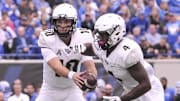 Oct 13, 2018; Memphis, TN, USA; UCF Knights quarterback McKenzie Milton (10) hands the ball off to UCF Knights running back Taj McGowan (4) during the first half against the Memphis Tigers at Liberty Bowl Memorial Stadium. Mandatory Credit: Justin Ford-Imagn Images