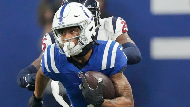 Colts receiver Josh Downs (blue jersey with white helmet) makes a catch and run in an important football game. 