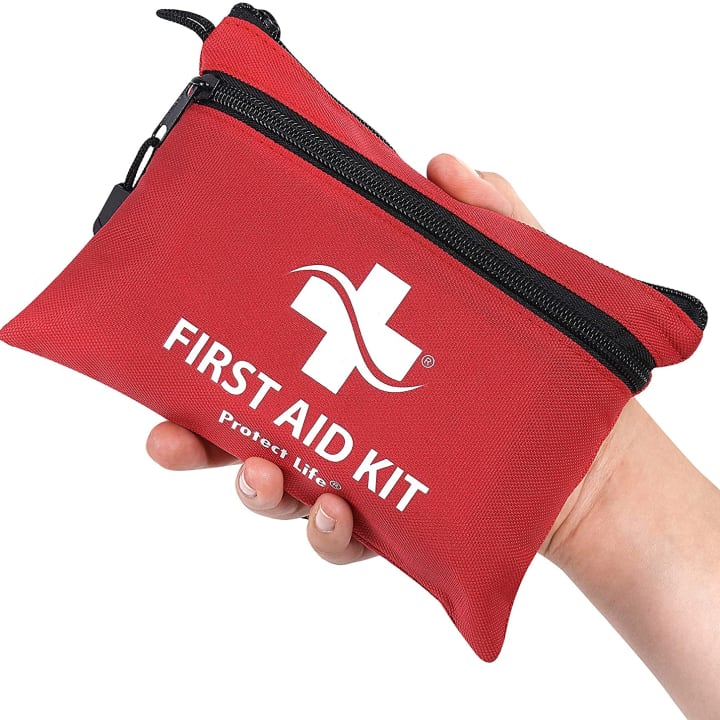 Protect Life First Aid Kit close-up, against white background, held by hand.