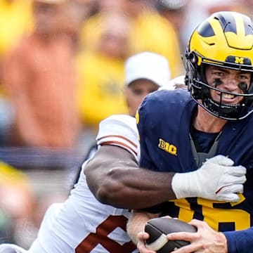 Michigan quarterback Davis Warren (16) is sacked by Texas linebacker Barryn Sorrell (88) during the second half at Michigan Stadium in Ann Arbor on Saturday, September 7, 2024.