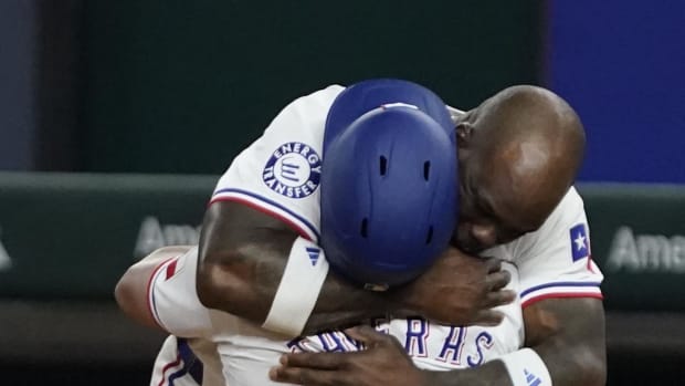 Adolis Garcia hugs Leody Taveras after Taveras' walk-off single in Saturday night.