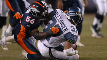 Dec. 3, 2006; Denver, CO, USA; Seattle Seahawks running back (37) Shaun Alexander gets tackled by Denver Broncos linebacker (56) Al Wilson at Invesco Field at Mile High in Denver, Colorado. Seattle defeated Denver 23-20.
