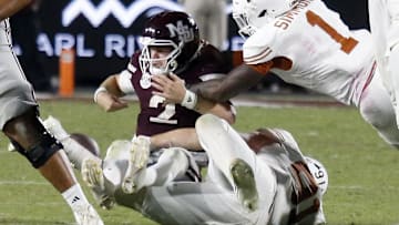 Texas Longhorns defensive linemen Ethan Burke (91) and Texas Longhorns defensive linemen Colin Simmons (1) force Mississippi State Bulldogs quarterback Blake Shapen (2) to fumble during overtime at Davis Wade Stadium at Scott Field.