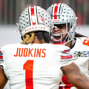 Ohio State running back Quinshon Judkins (left) celebrates with tight end Gee Scott Jr. during Monday's national title game.