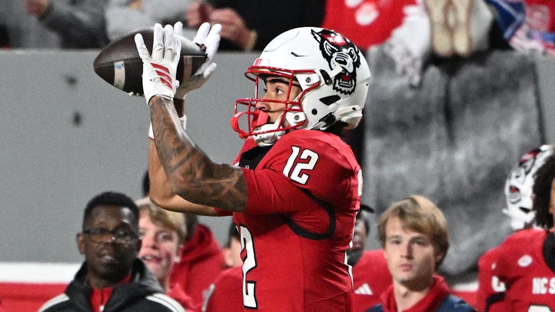 Nov 1, 2025; Raleigh, North Carolina, USA;  North Carolina State Wolfpack wide receiver Teddy Hoffmann (12) catches a pass against Georgia Tech Yellow Jackets defensive back Omar Daniels (9) during the first quarter at Carter-Finley Stadium. Mandatory Credit: Zachary Taft-Imagn Images