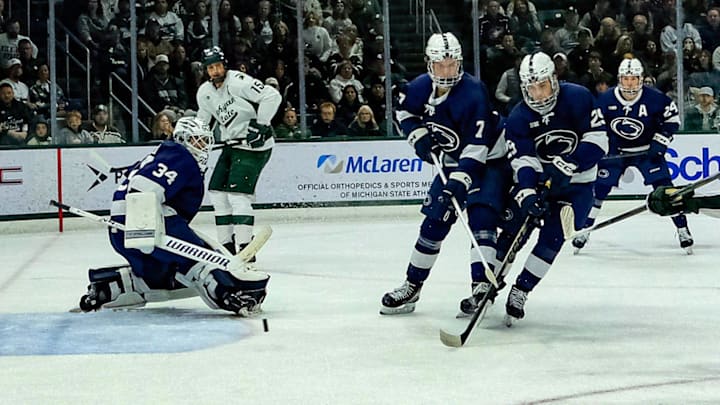 Michigan State's Porter Martone (22) shoots the puck past defenders and Penn State goaltender Josh Fleming (34) late in the first period at Munn Ice Arena Saturday, Nov. 8, 2025.