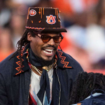 Former Auburn quarterback Cam Newton jokes with his kids on the sideline as Auburn Tigers take on Georgia Bulldogs at Jordan-Hare Stadium in Auburn, Ala. on Saturday, Oct. 11, 2025. Auburn Tigers lead Georgia Bulldogs 10-3 at halftime.