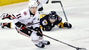 Niagara IceDogs forward Kevin He controls the puck near Erie Otters forward Pano Fimis in the first period of an Ontario Hockey League game at Erie Insurance Arena in Erie on Feb. 14, 2024.