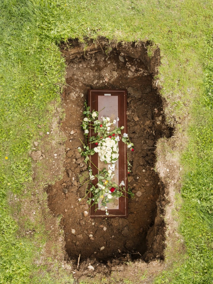 Flowers on a coffin in the ground